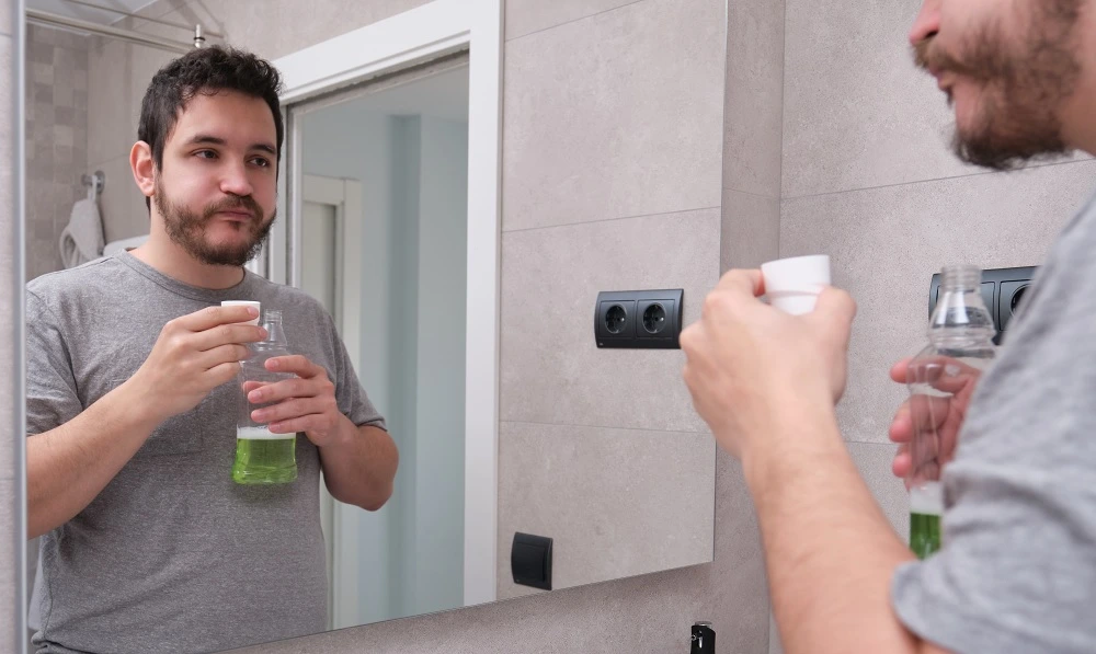 man-rinsing-mouth-with-green-mouthwash