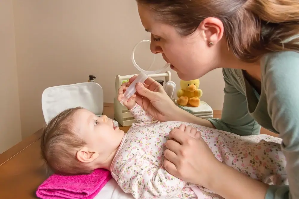 mother-cleaning-mucus-of-baby-with-nasal-aspirator