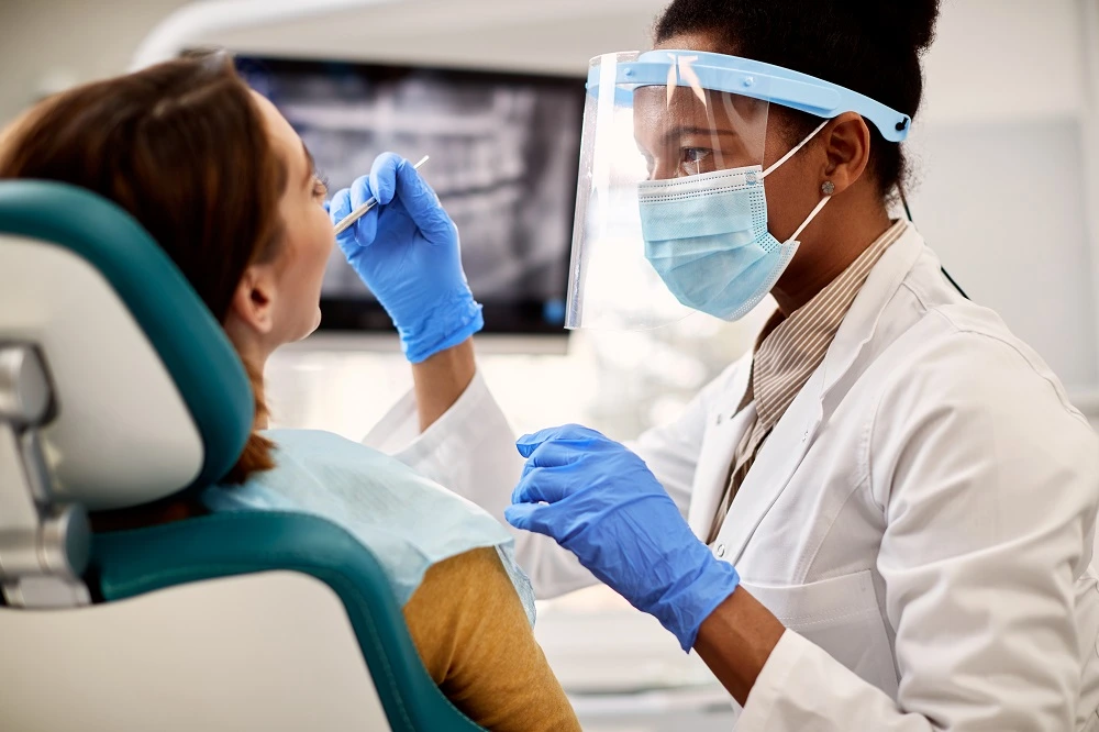 black-female-dentist-examining-woman-s-teeth