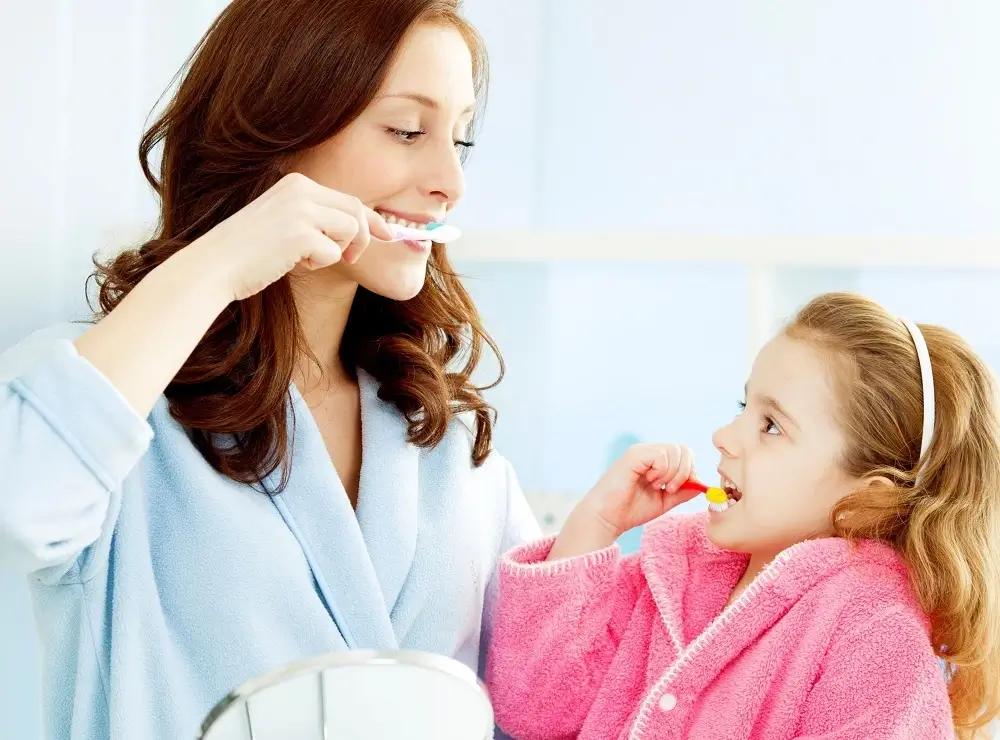 mom-teaching-her-daughter-to-brush