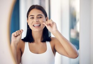 Higiene bucal como método para prevenir las caries por debajo de las coronas dentales.