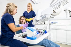 Mujer visita al dentista donde le explican como puede evitar tener caries debajo de las coronas dentales.