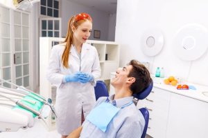 Odontóloga explica a su paciente la importancia del examen oral completo dos veces al año