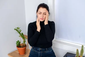 Mujer con dolor de cabeza a causa de las muelas del juicio