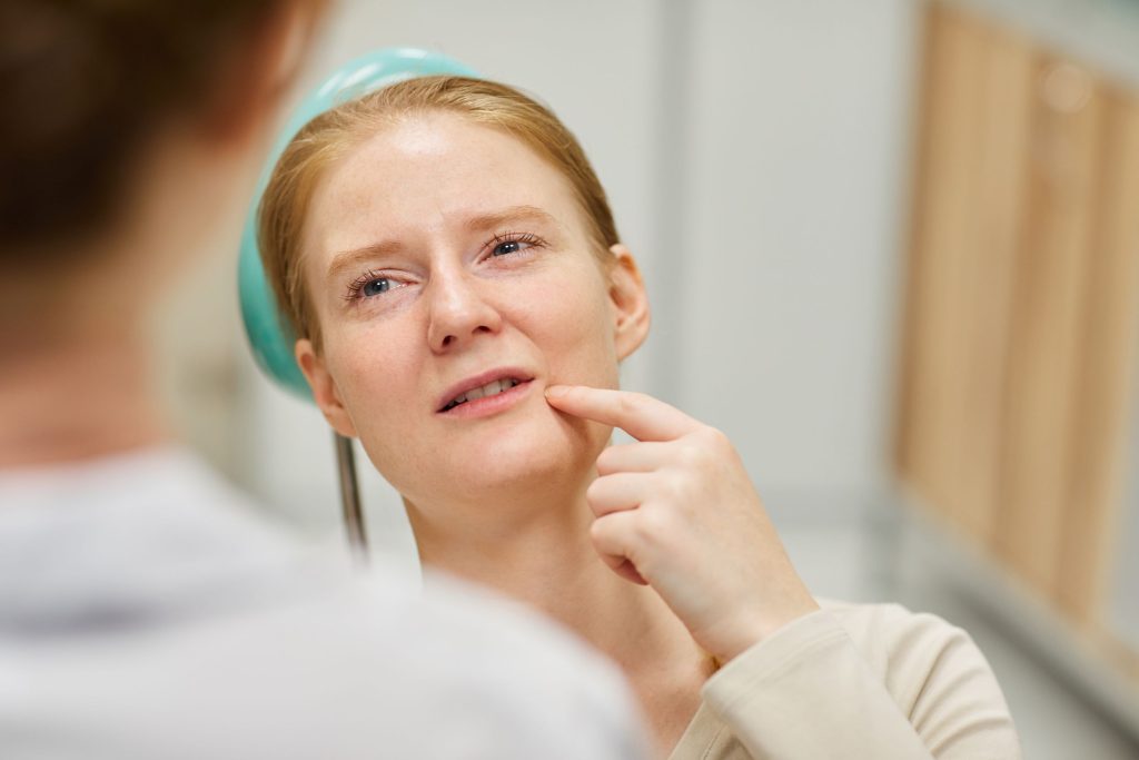 Mujer con dolor dental debido a realizar examen oral con poca frecuencia.