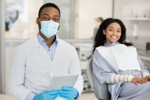 Dental Services. Black Dentist And Female Patient Posing In Modern Clinic Interior