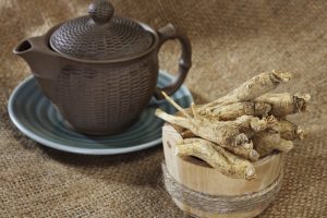 a bowl of root in a bowl next to a teapot