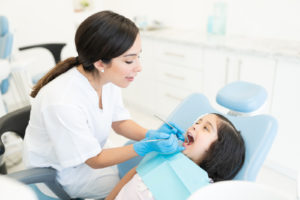 Dentist Checking Teeth Of Kid At Clinic