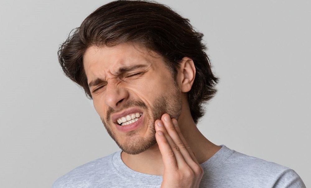 man experiencing oral discomfort