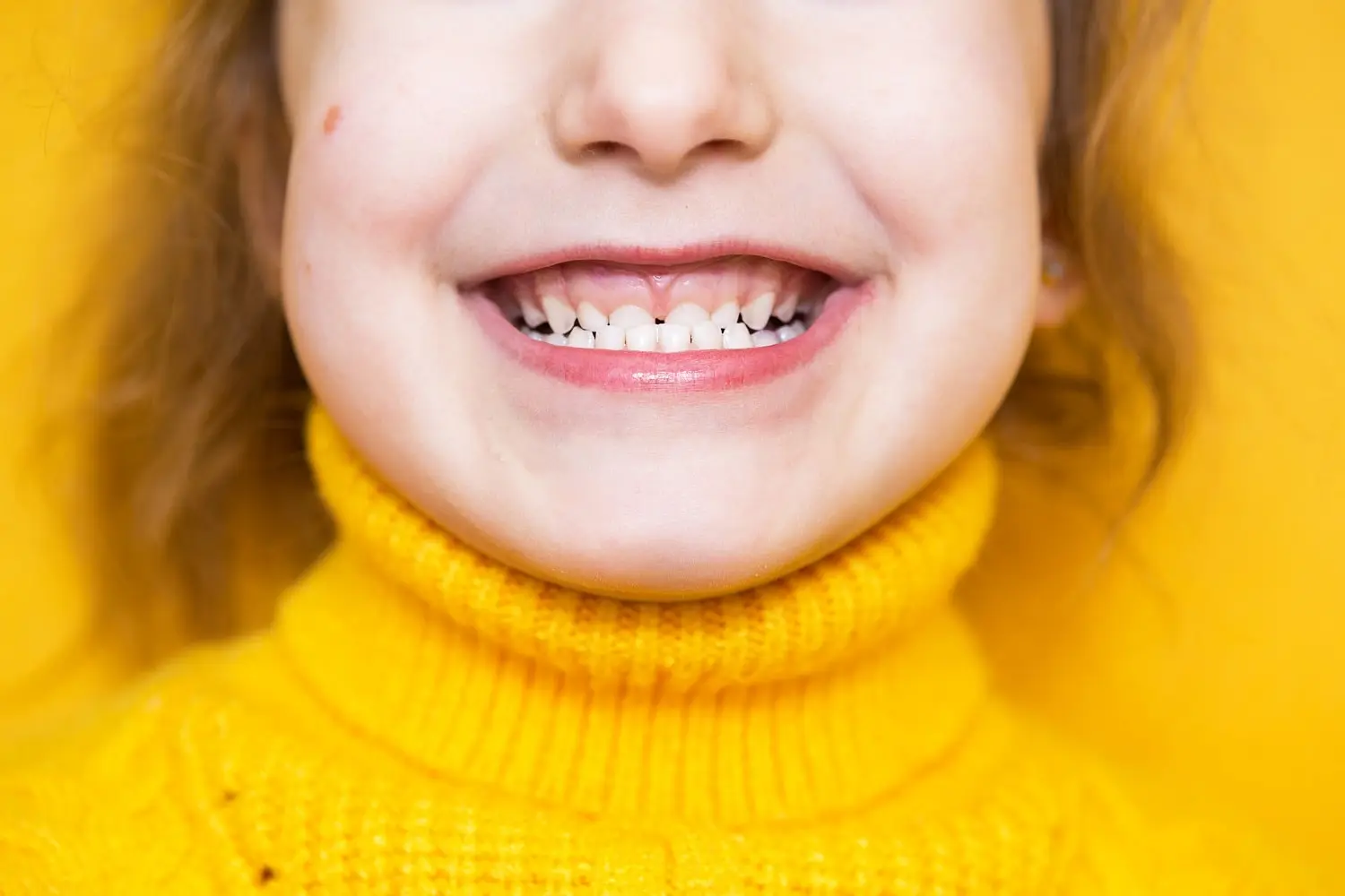 little girl shows her teeth