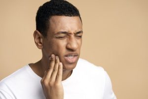 portrait-of-unhealthy-man-pressing-sore-cheek-suf-2022-11-08-00-43-39-utc-min
