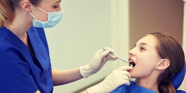 dentist is examining the girl's tongue