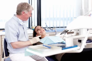 Mujer en chequeo dental. ¿Por Qué Los Chequeos Dentales Son Esenciales? Dentista explica a su paciente la importancia del chequeo dental.