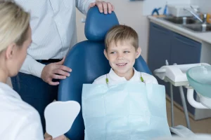Niño en chequeo dental. ¿Por Qué Los Chequeos Dentales Son Esenciales? Prevención de enfermedades? Niños en chequeo dental para evitar molestias dentales.
