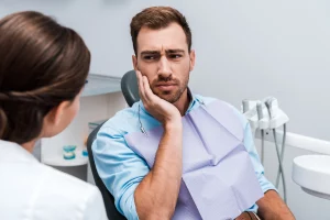 Hombre con dolor dental. Hombre en consultorio dental con dolor de dientes.