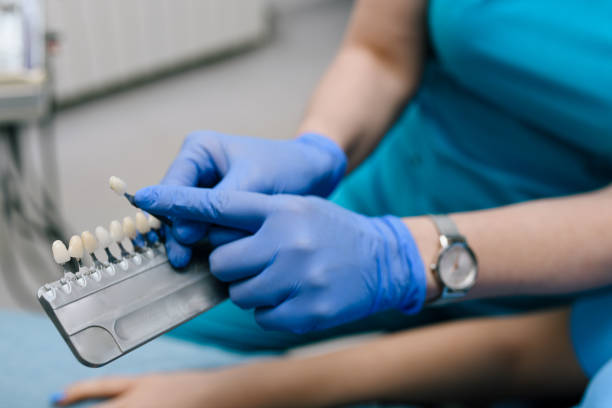 A dentist is showing dental veneers to her patient.