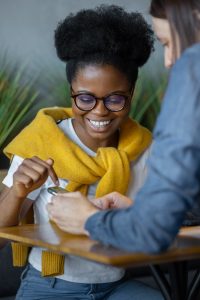 beautiful and happy african american woman smiling and chatting with friends, chatting online