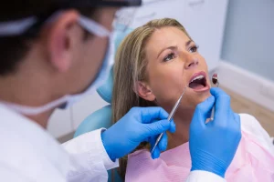 Mujer en consulta dental. Foto de dentista revisando la boca de una mujer.