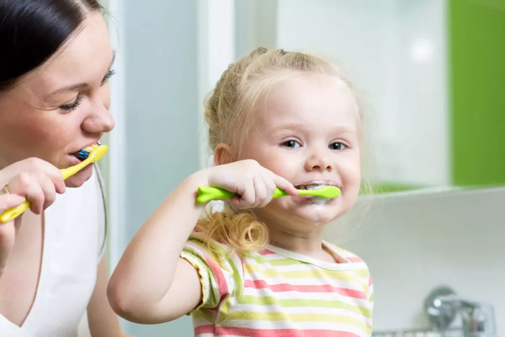 Mother and daughter brushing their teeth