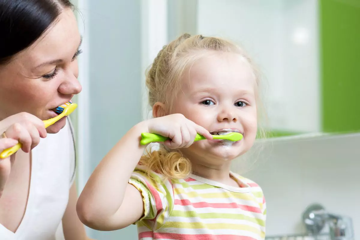 Mother and daughter brushing their teeth