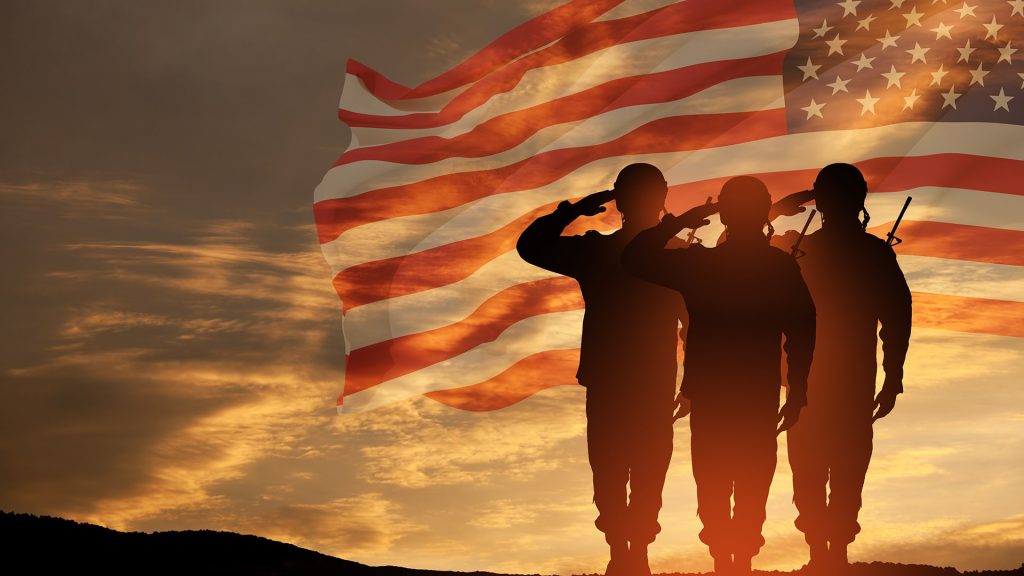 silhouettes of people saluting with a flag in the background